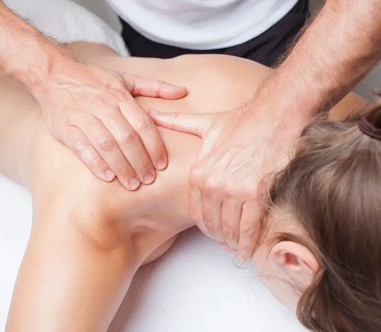 Woman receiving a shoulder massage from a male